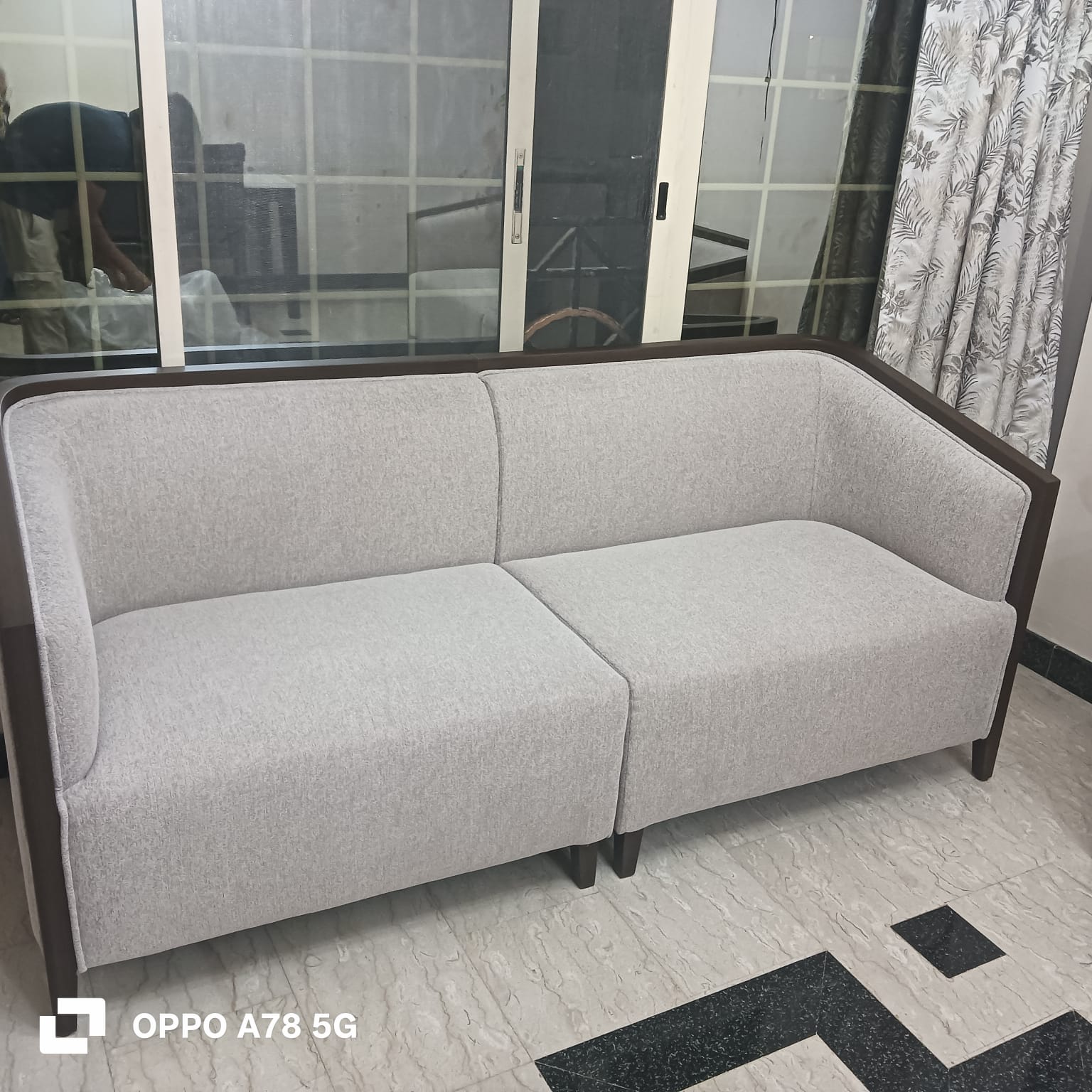 Custom grey fabric sofa with wood trim, angled view, Dune Home Dubai